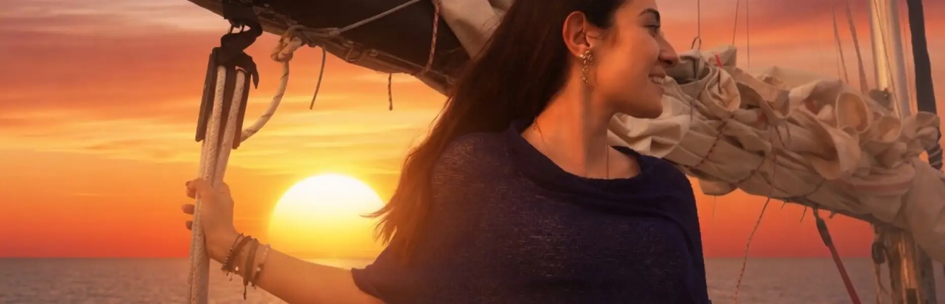 Femme profitant d’une aube en voilier privé face à la mer à Barcelone