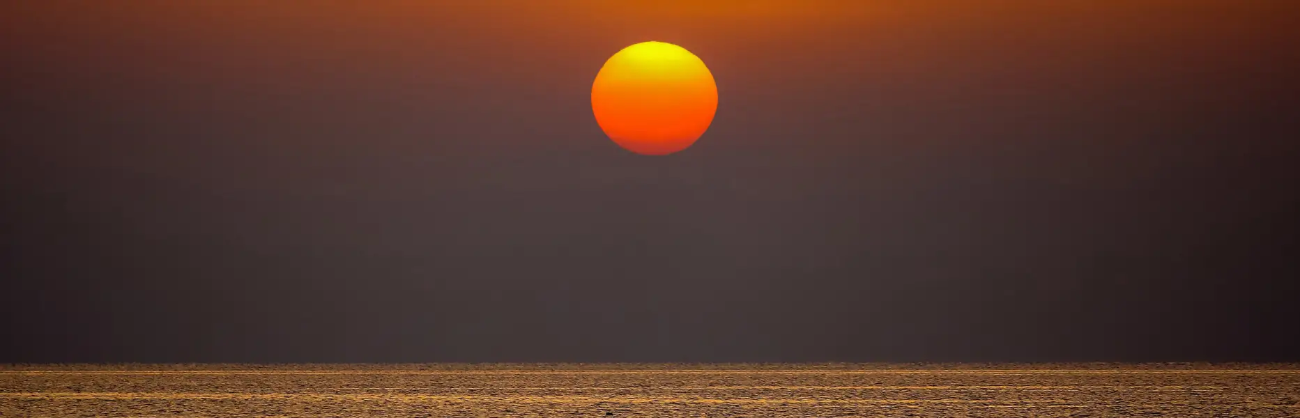 Soleil se levant sur une mer calme lors d’une aube à Barcelone vue depuis un voilier