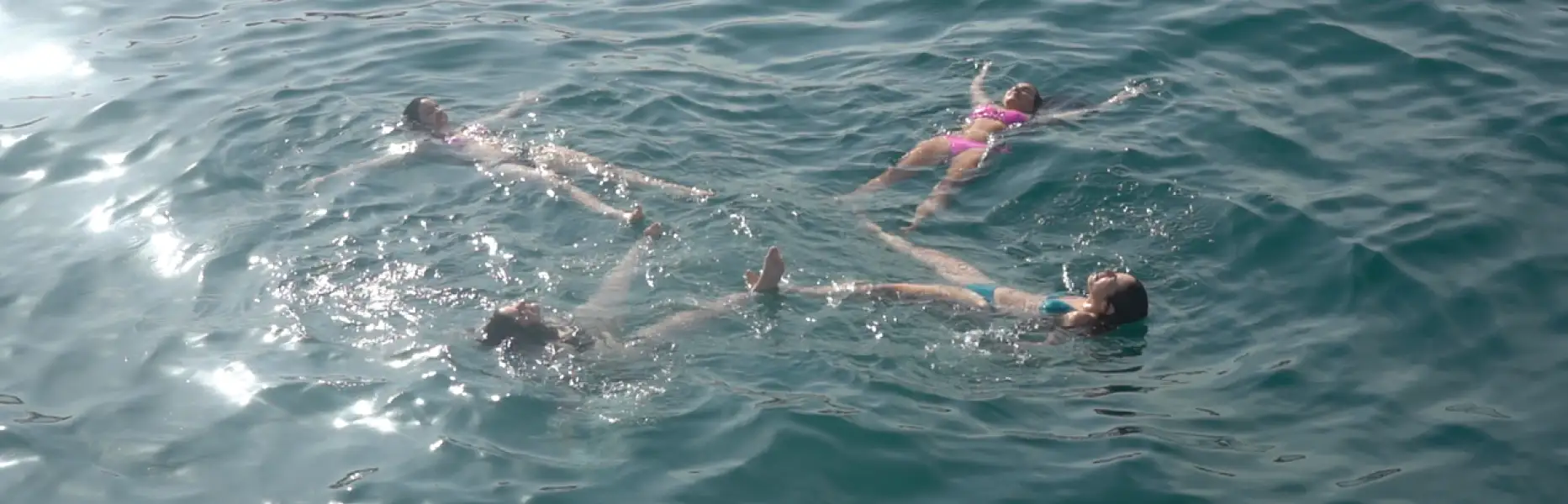 Groupe de personnes flottant détendues dans la mer lors d’une promenade en bateau au coucher du soleil à Barcelone