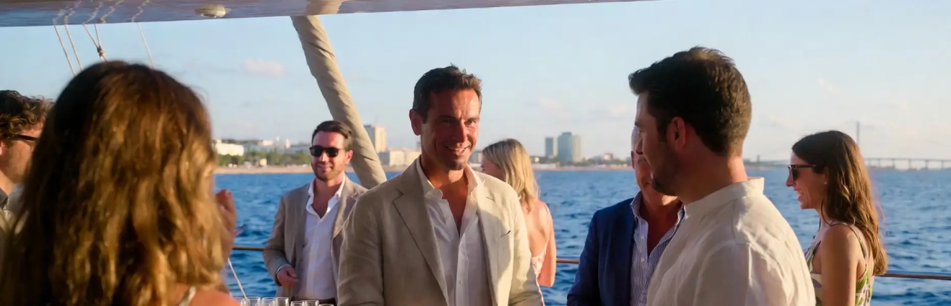 Groupe de personnes profitant d’un événement de luxe à bord d’un yacht charter au coucher du soleil face à la mer