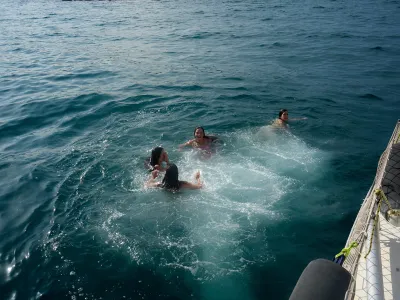 Mujer sonriente navegando un velero en mar abierto